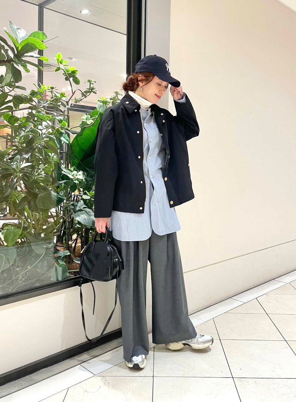 ブラック系のショルダーバッグ、ブルー系のTシャツ/カットソー、ホワイト系のスニーカーを着用したレディースの冬コーディネートの2枚目の写真