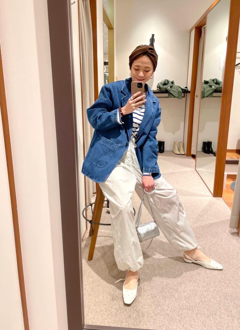 シルバー系のショルダーバッグ、ホワイト系のパンプス、ブルー系のデニムジャケットを着用したレディースの冬コーディネートの6枚目の写真