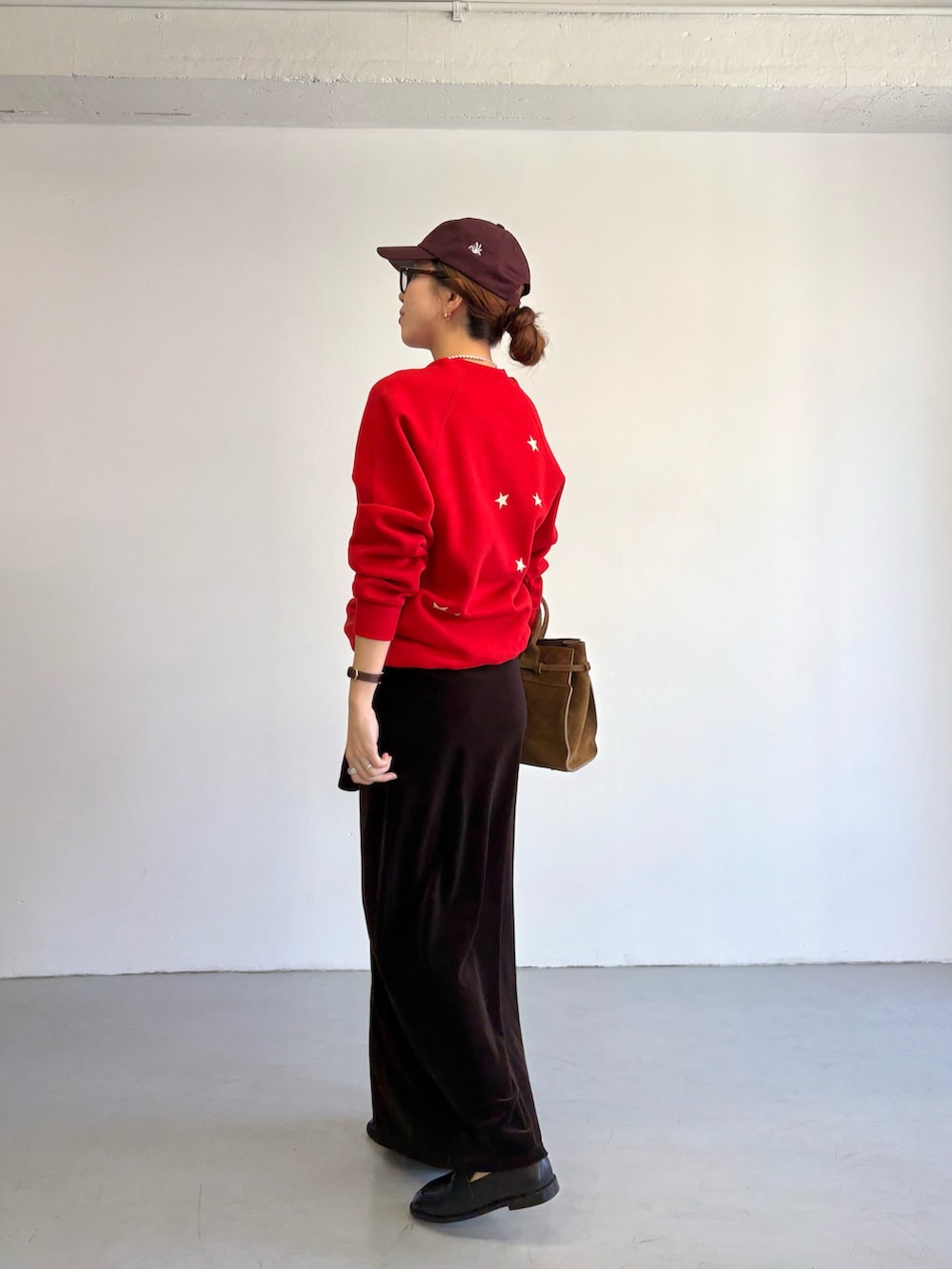 レッド系のスウェット、ブラウン系のトートバッグ、ブラック系のローファーを着用したレディースの秋コーディネートの6枚目の写真