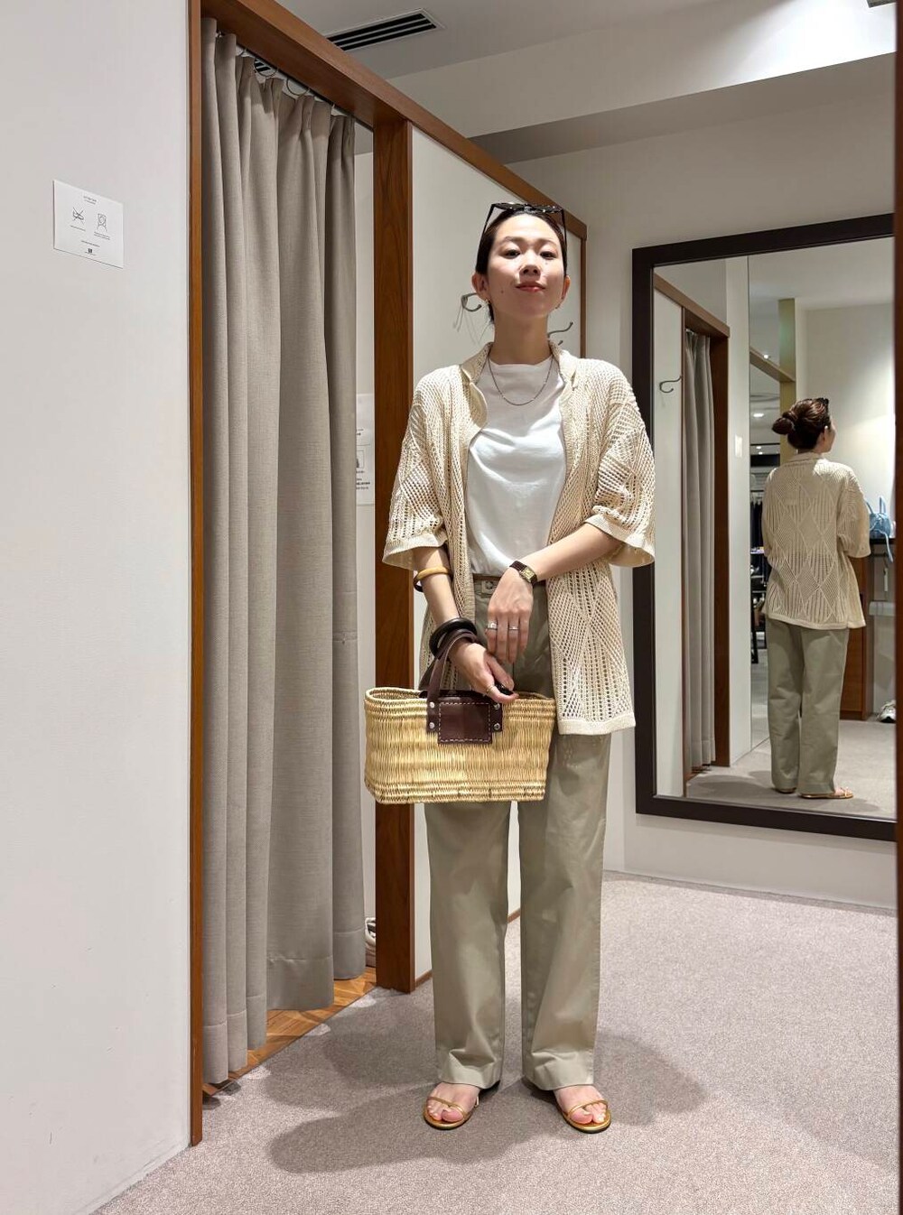 ブラウン系のかごバッグ、ホワイト系のその他アウター、ゴールド系のサンダルを着用したレディースの春コーディネートの4枚目の写真