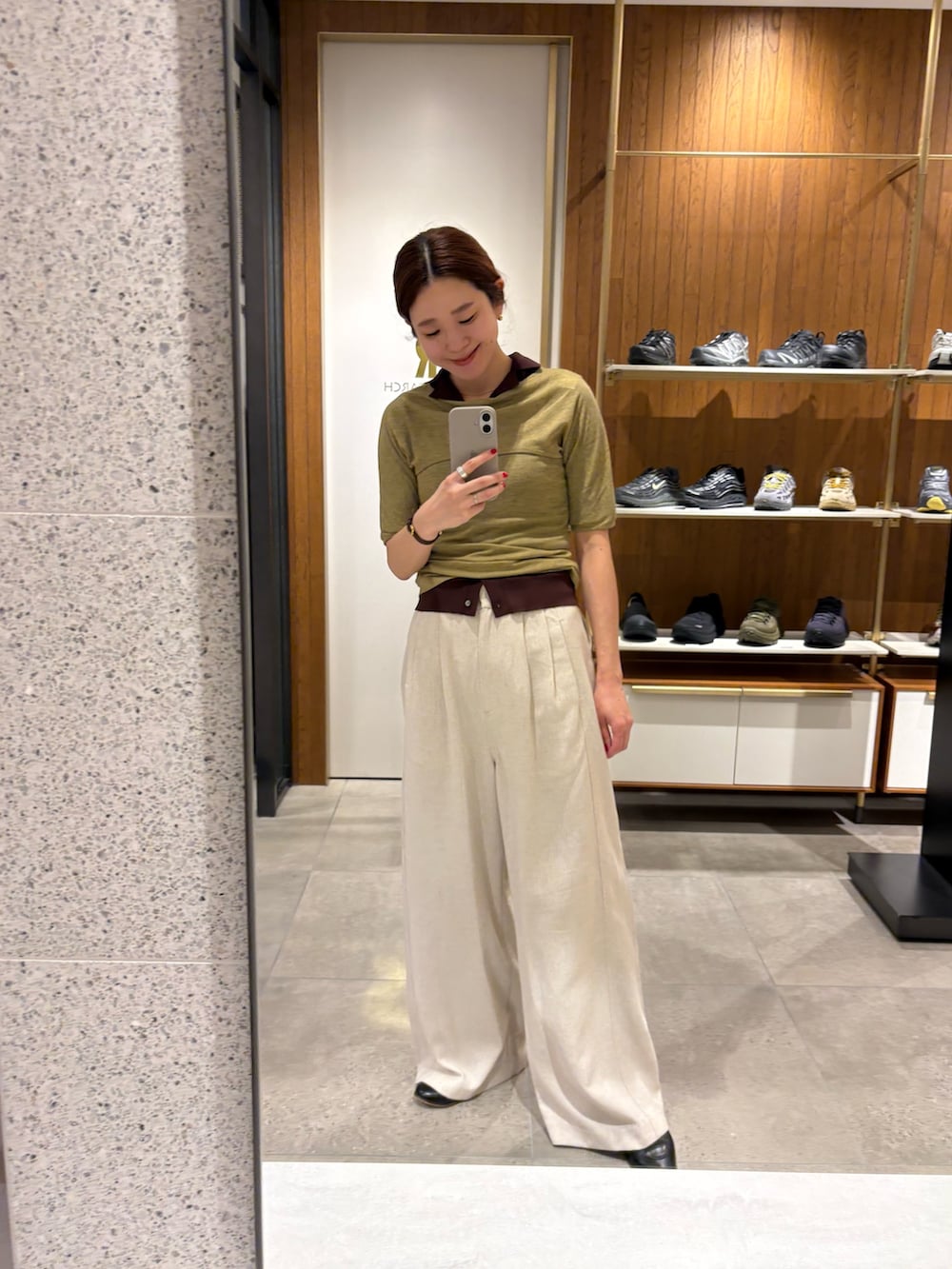 ホワイト系のその他パンツ、グリーン系のTシャツ/カットソー、ベージュ系のハンドバッグを着用したレディースの春コーディネートの7枚目の写真