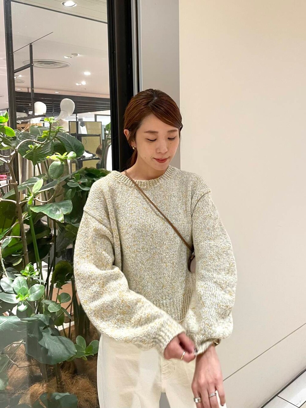 ホワイト系のデニムパンツ、ブラウン系のブーツ、ホワイト系のニット/セーターを着用したレディースの秋コーディネートの4枚目の写真