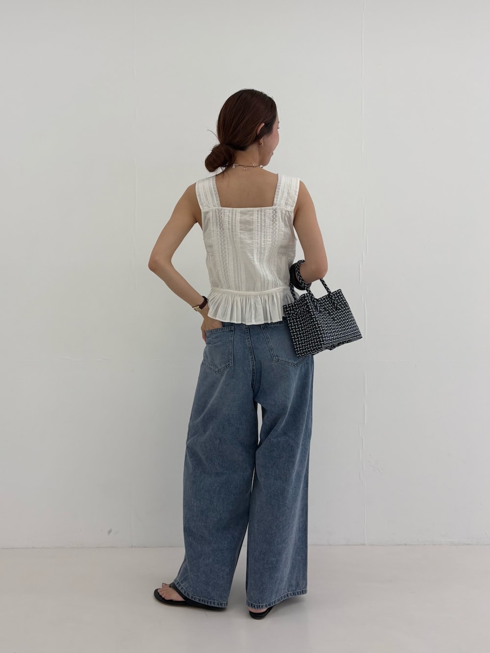 ブルー系のデニムパンツ、その他のトートバッグ、ホワイト系のシャツ/ブラウスを着用したレディースの夏コーディネートの4枚目の写真
