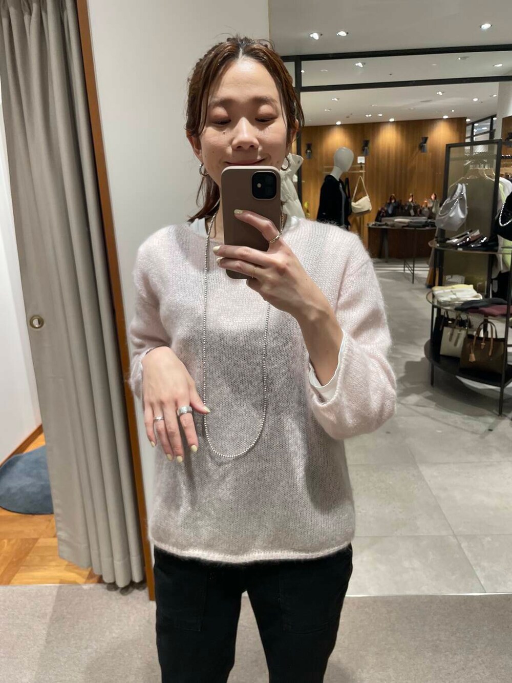 ブラック系のボストンバッグ、ブラック系のダウンジャケット/コート、ピンク系のニット/セーターを着用したレディースの冬コーディネートの7枚目の写真