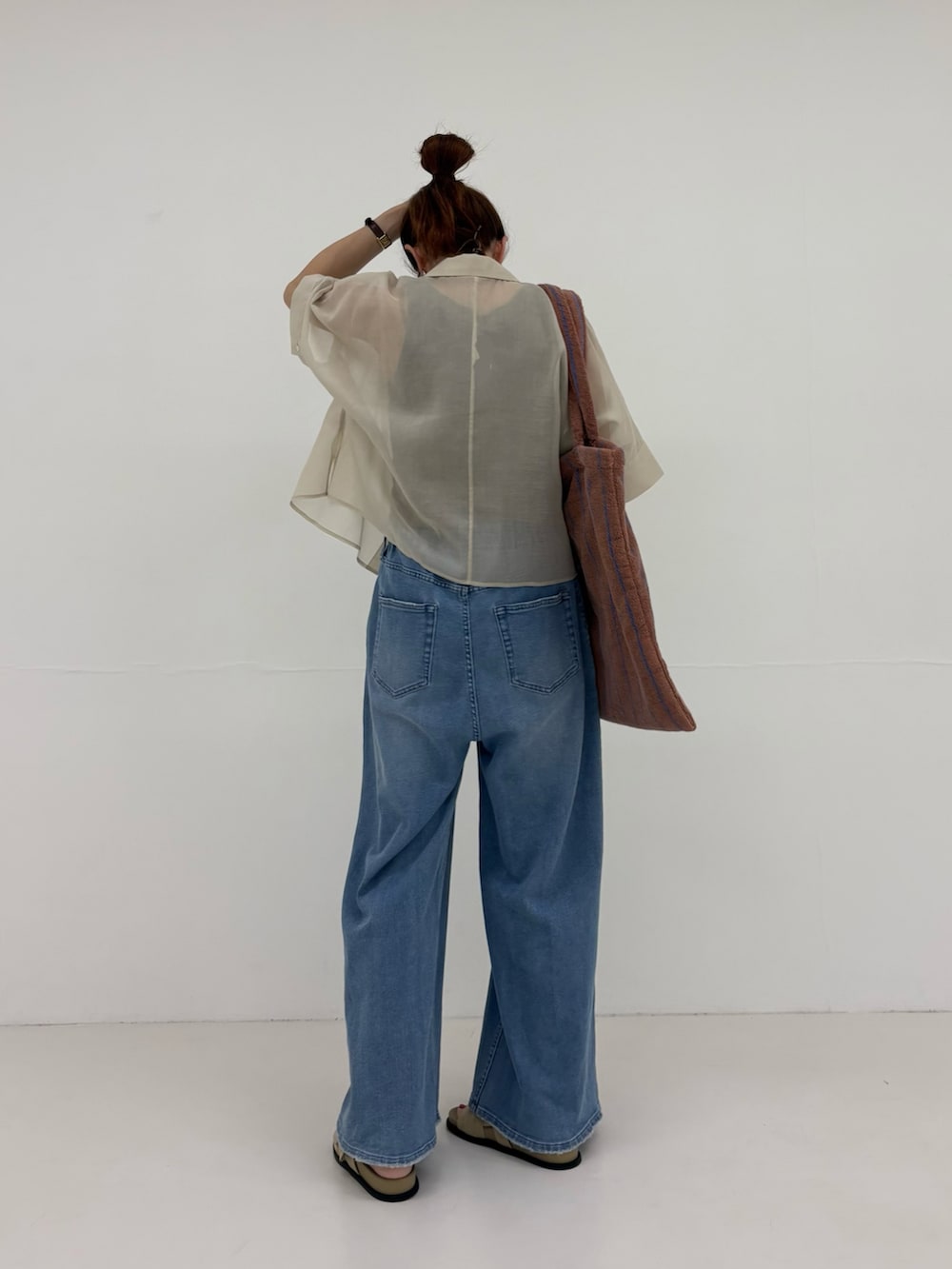 グレー系のシャツ/ブラウス、ブルー系のデニムパンツ、イエロー系のトートバッグを着用したレディースの春コーディネートの3枚目の写真