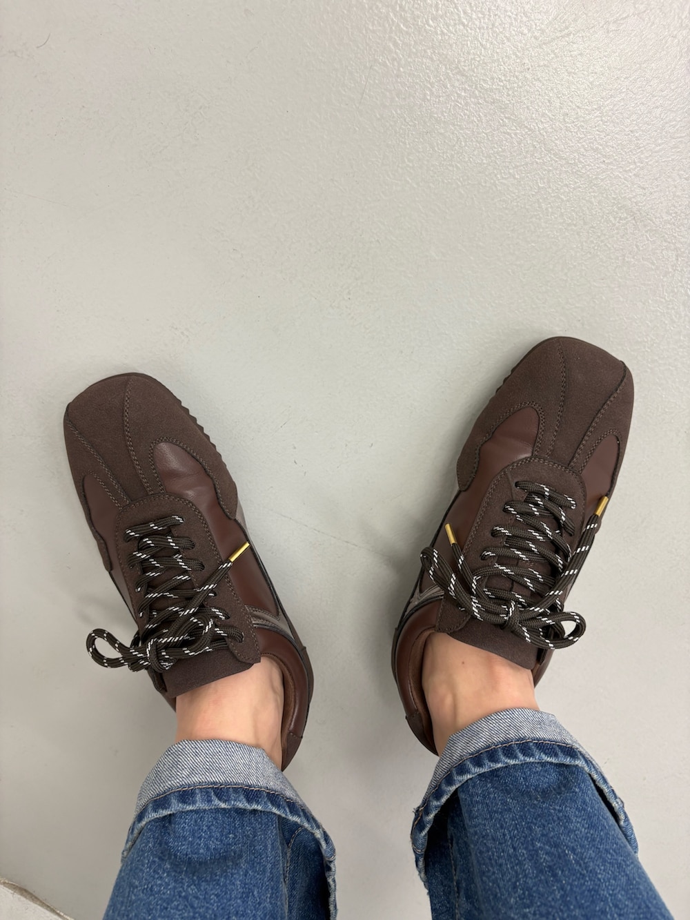 グレー系のダウンジャケット/コート、ブラック系のその他パンツ、ブラウン系のスニーカーを着用したレディースの秋コーディネートの7枚目の写真