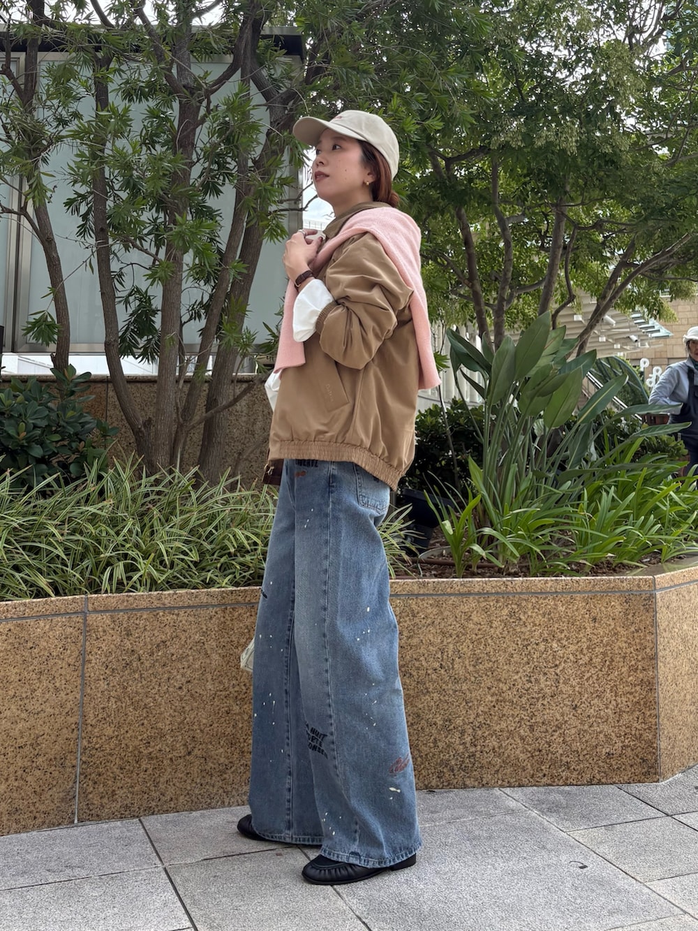 ブルー系のデニムパンツ、ベージュ系のダウンジャケット/コート、ホワイト系のシャツ/ブラウスを着用したレディースの秋コーディネートの2枚目の写真