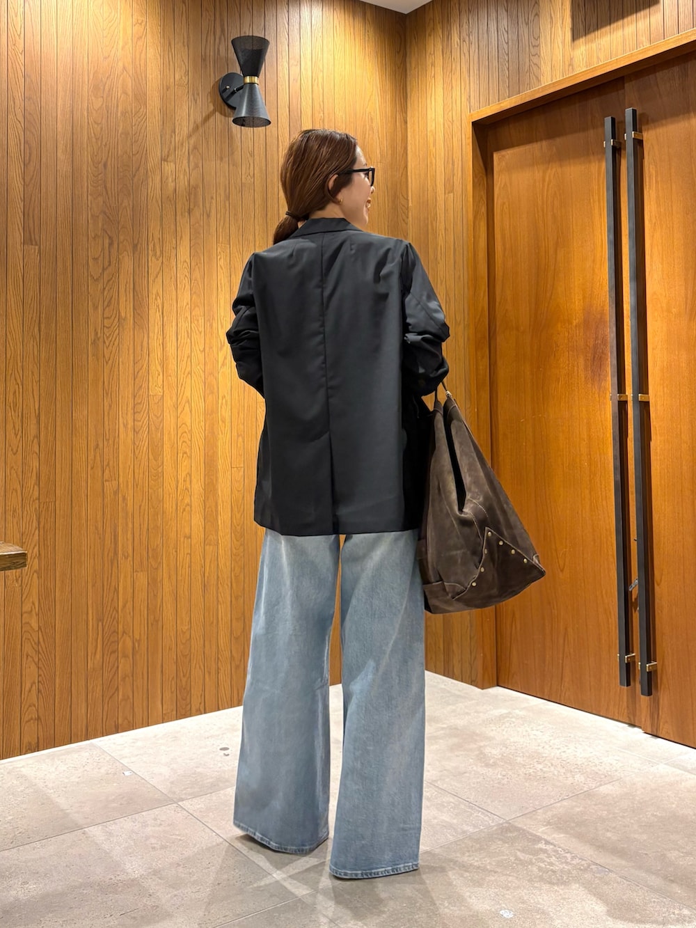 ブルー系のデニムパンツ、ホワイト系のTシャツ/カットソー、ブラック系のテーラードジャケットを着用したレディースの夏コーディネートの4枚目の写真