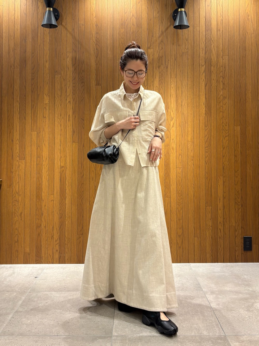 ベージュ系のスカート、ホワイト系のシャツ/ブラウス、ブラック系のショルダーバッグを着用したレディースの春コーディネートの4枚目の写真