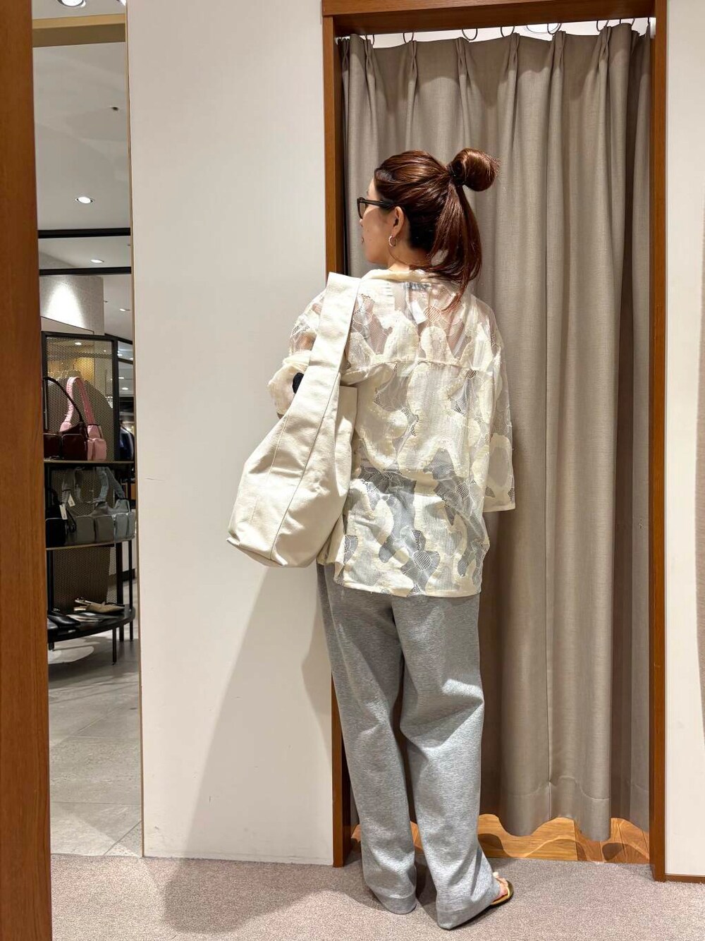 ベージュ系のトートバッグ、グレー系のその他パンツ、ゴールド系のネックレスを着用したレディースの春コーディネートの4枚目の写真