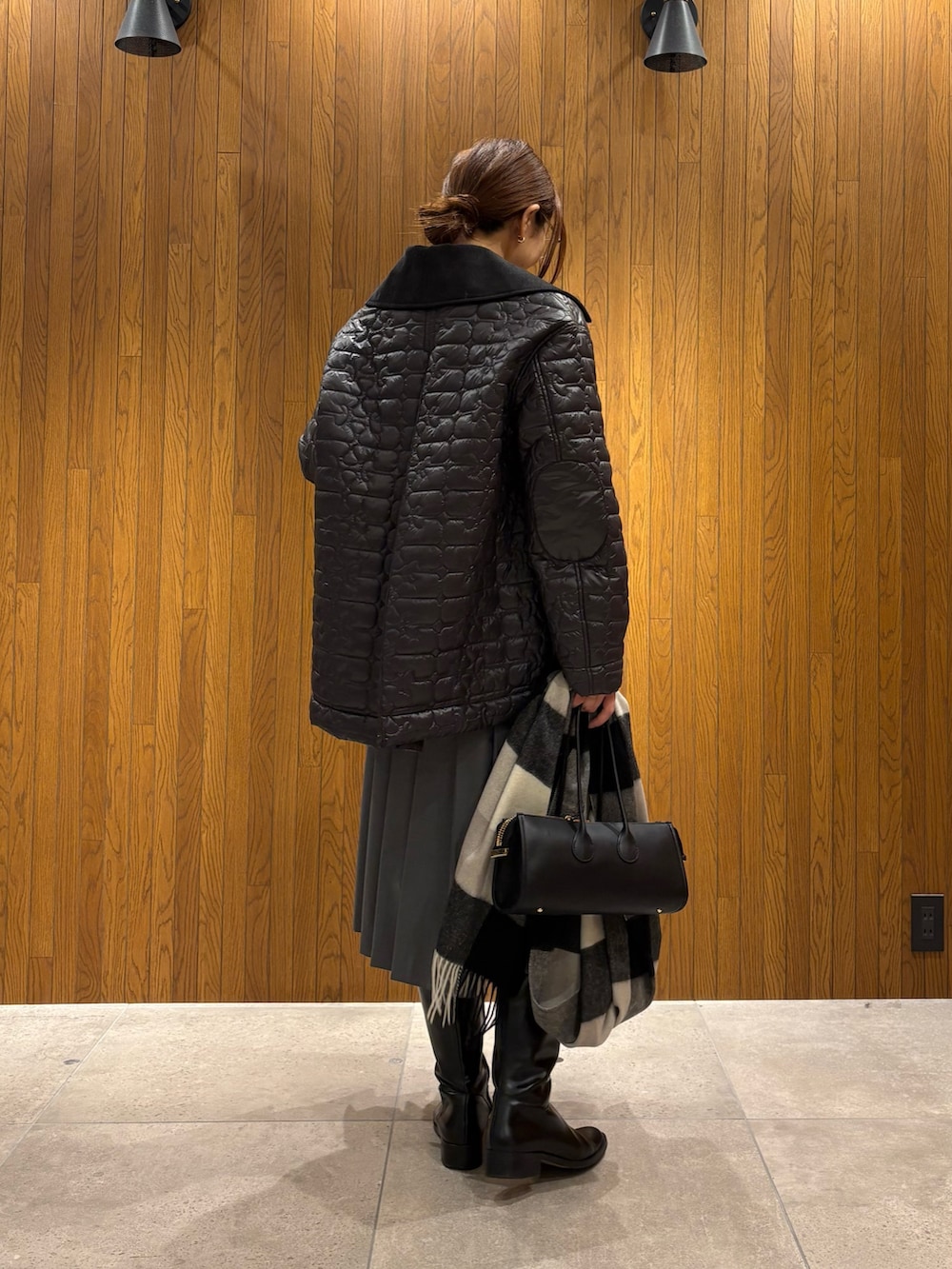 グレー系のダウンジャケット/コート、グリーン系のスカート、ブラック系のショルダーバッグを着用したレディースの冬コーディネートの3枚目の写真