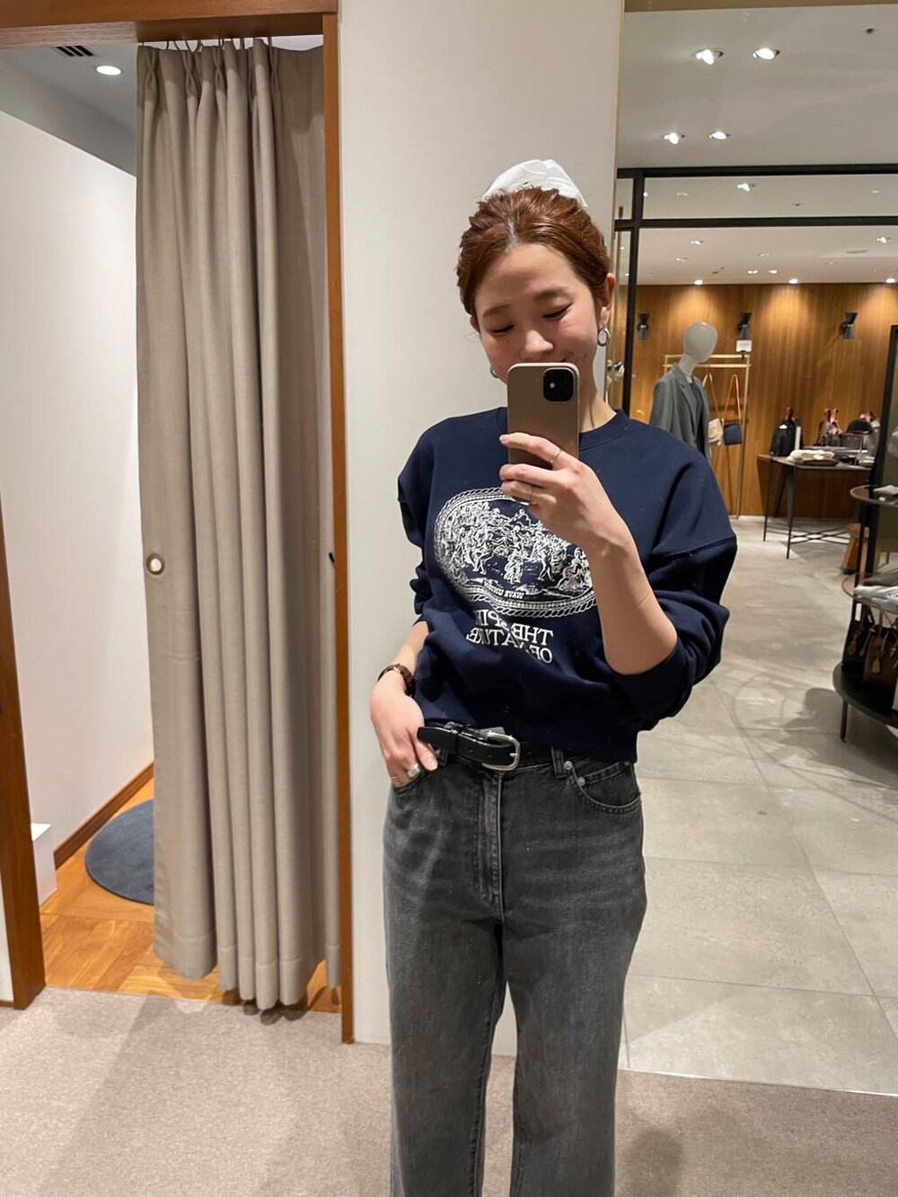 ブラック系のデニムパンツ、ブラック系のトートバッグ、ブルー系のスウェットを着用したレディースの冬コーディネートの4枚目の写真