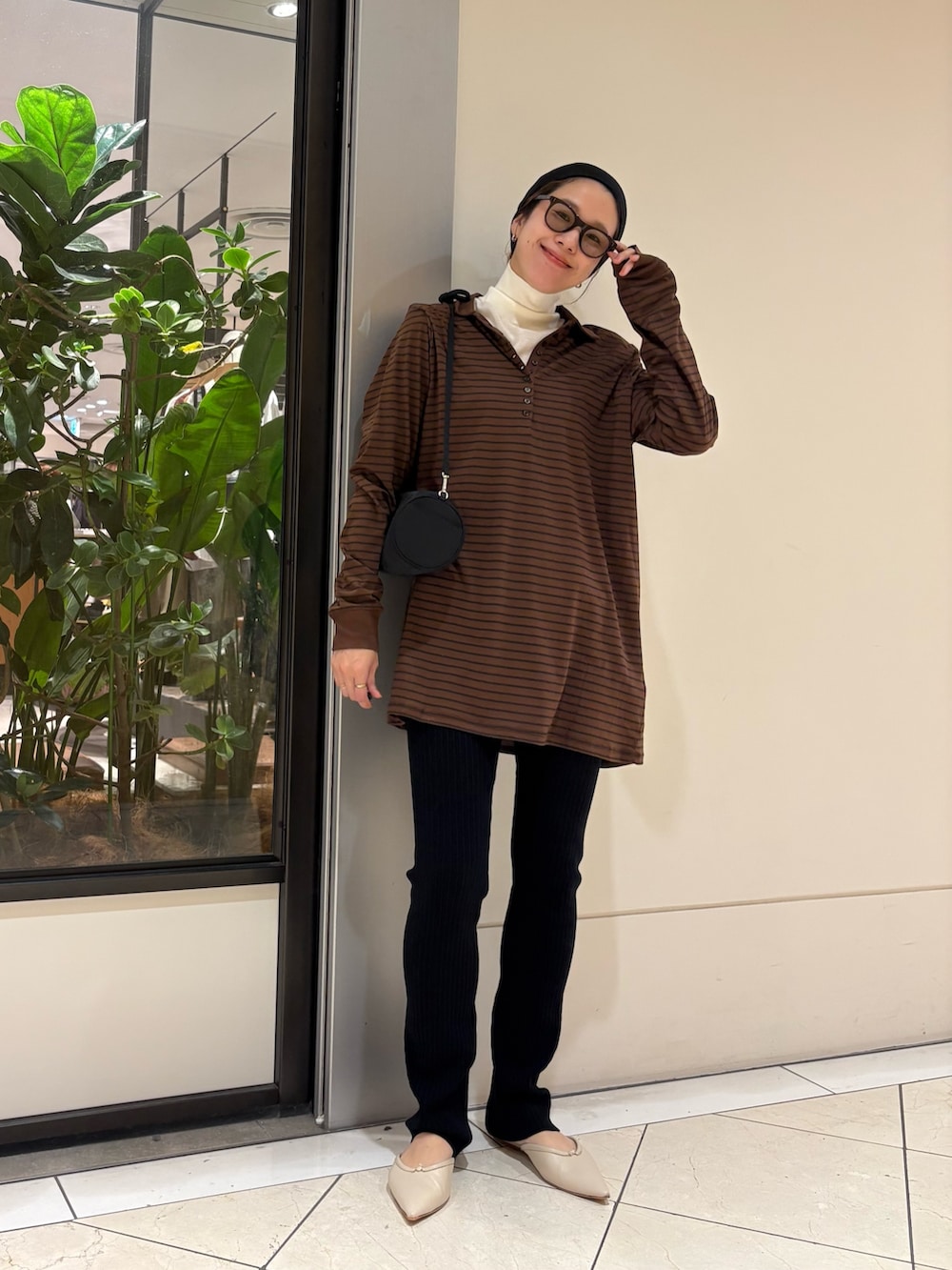 ブラウン系のポロシャツ、ブラック系のその他パンツ、ブラック系のハンドバッグを着用したレディースの秋コーディネートの6枚目の写真