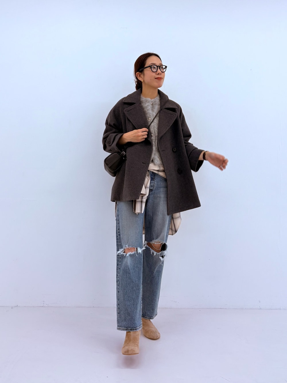 ブルー系のデニムパンツ、グリーン系のカーディガン/ボレロ、ホワイト系のピーコートを着用したレディースの秋コーディネートの2枚目の写真