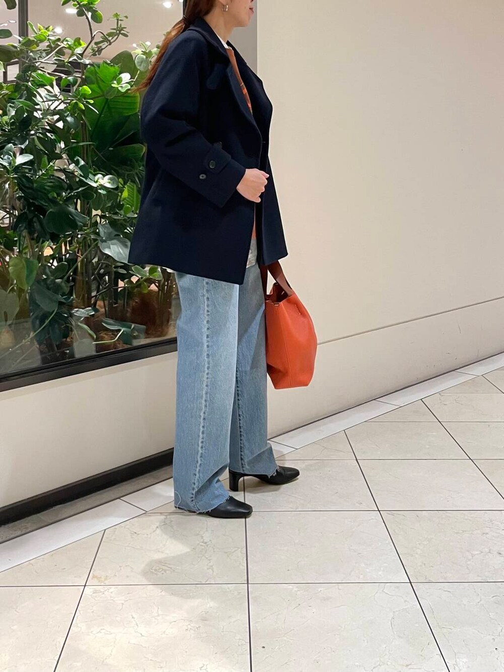 ブルー系のピーコート、ブルー系のデニムパンツ、ブラック系のブーツを着用したレディースの冬コーディネートの3枚目の写真