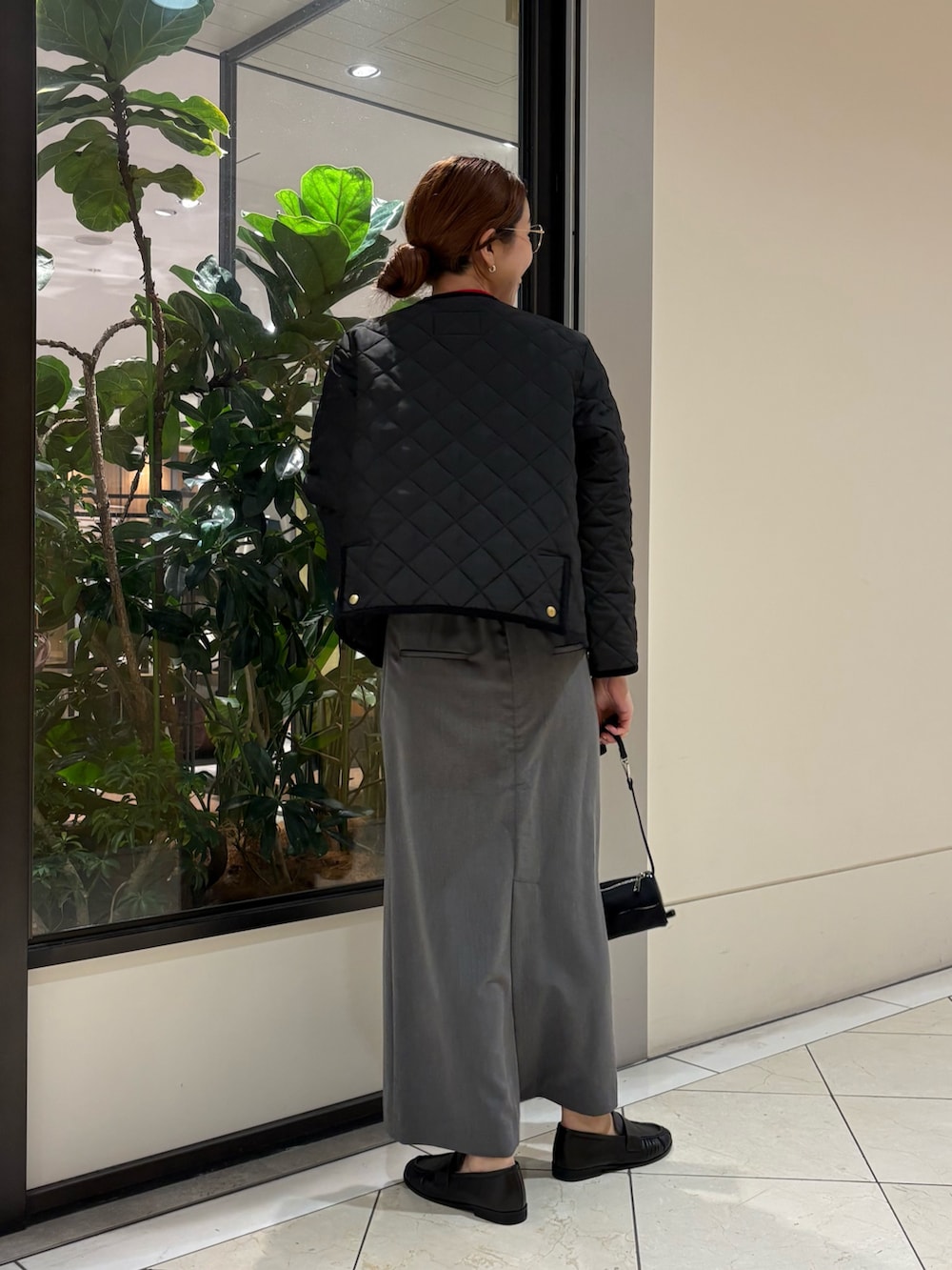 ブラック系のダウンジャケット/コート、レッド系のニット/セーター、ブラック系のハンドバッグを着用したレディースの秋コーディネートの4枚目の写真