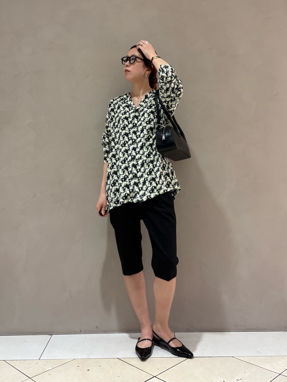 ブラック系のその他パンツ、ブラック系のパンプス、ホワイト系のシャツ/ブラウスを着用したレディースの春コーディネートの5枚目の写真