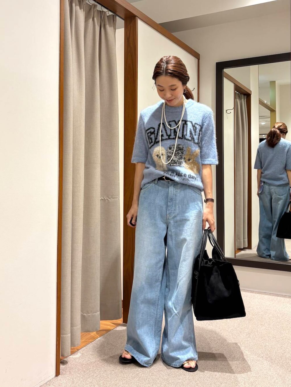 ブルー系のデニムパンツ、ブラック系のサンダルを着用したレディースの夏コーディネートの4枚目の写真