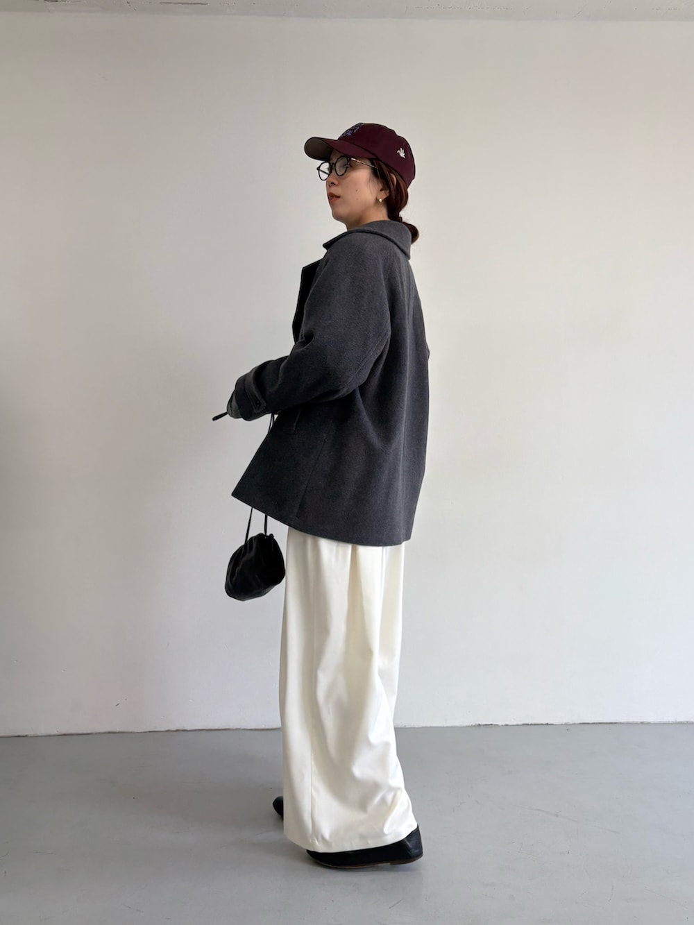 グレー系のピーコート、ホワイト系のその他パンツ、シルバー系のショルダーバッグを着用したレディースの冬コーディネートの5枚目の写真