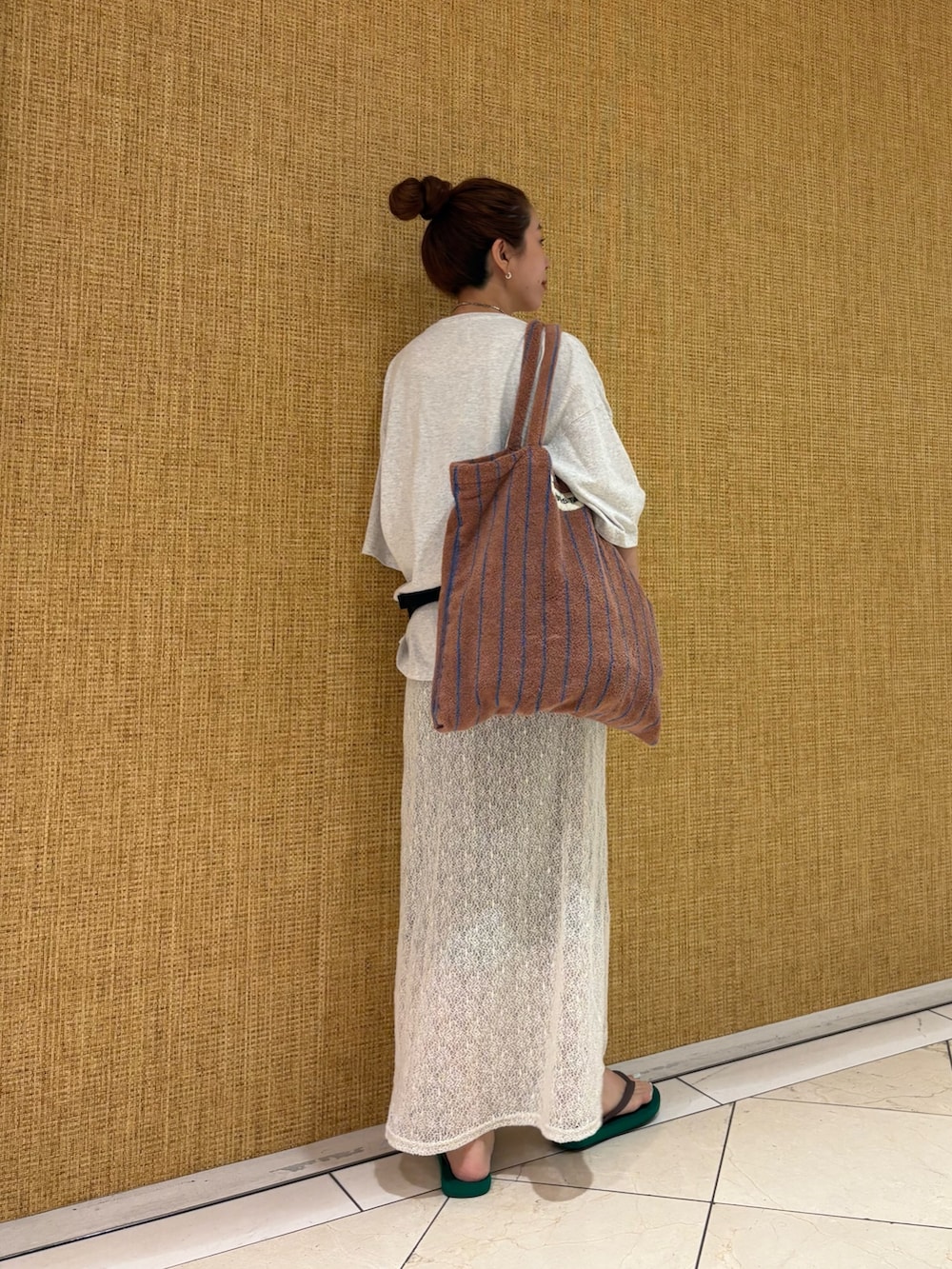 グレー系のTシャツ/カットソー、ホワイト系のスカート、イエロー系のトートバッグを着用したレディースの夏コーディネートの4枚目の写真