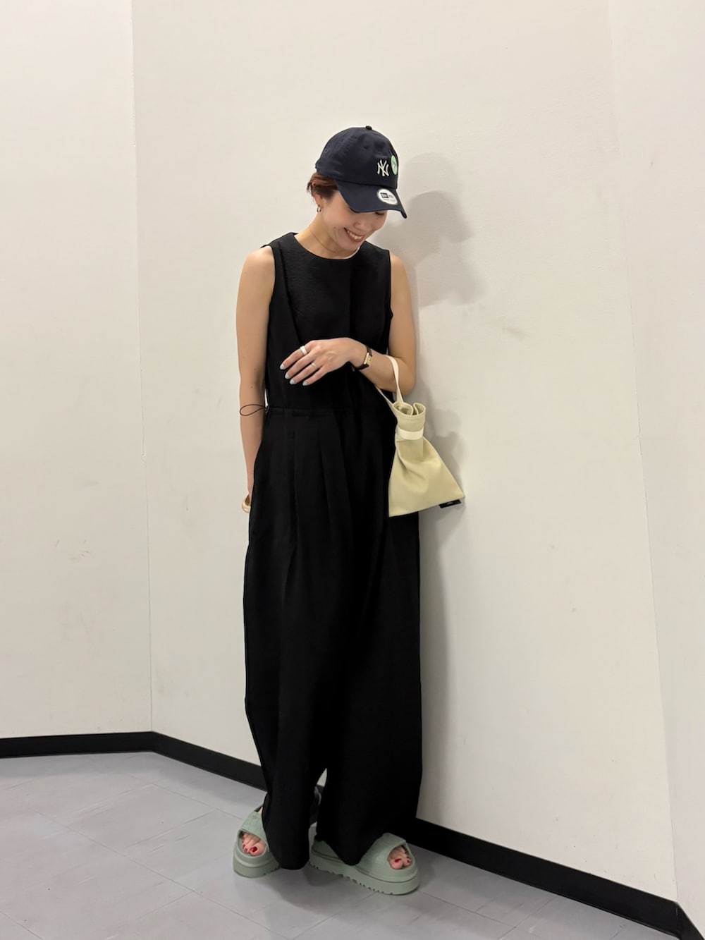 ブラック系のその他パンツ、ホワイト系のハンドバッグ、ブルー系のキャップを着用したレディースの春コーディネートの5枚目の写真