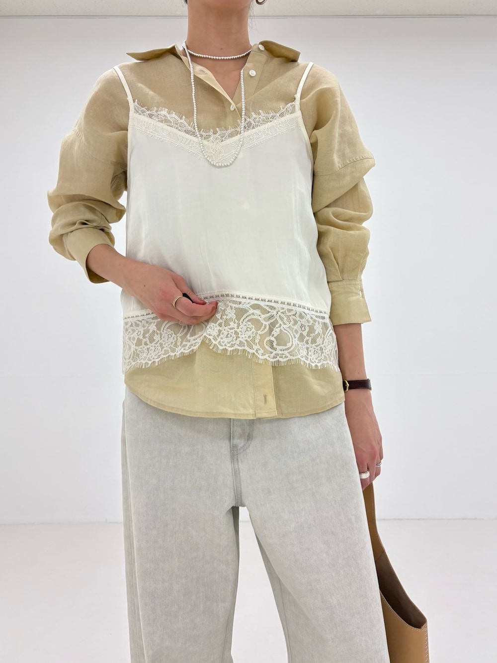 ホワイト系のキャミソール、グレー系のデニムパンツ、ベージュ系のシャツ/ブラウスを着用したレディースの冬コーディネートの6枚目の写真