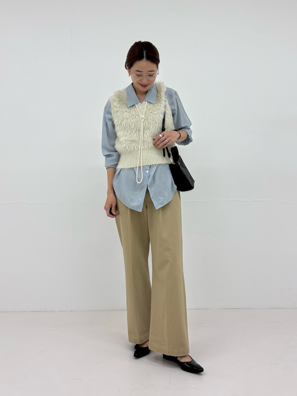 ホワイト系のベスト、ベージュ系のその他パンツ、ブルー系のシャツ/ブラウスを着用したレディースの秋コーディネートの5枚目の写真