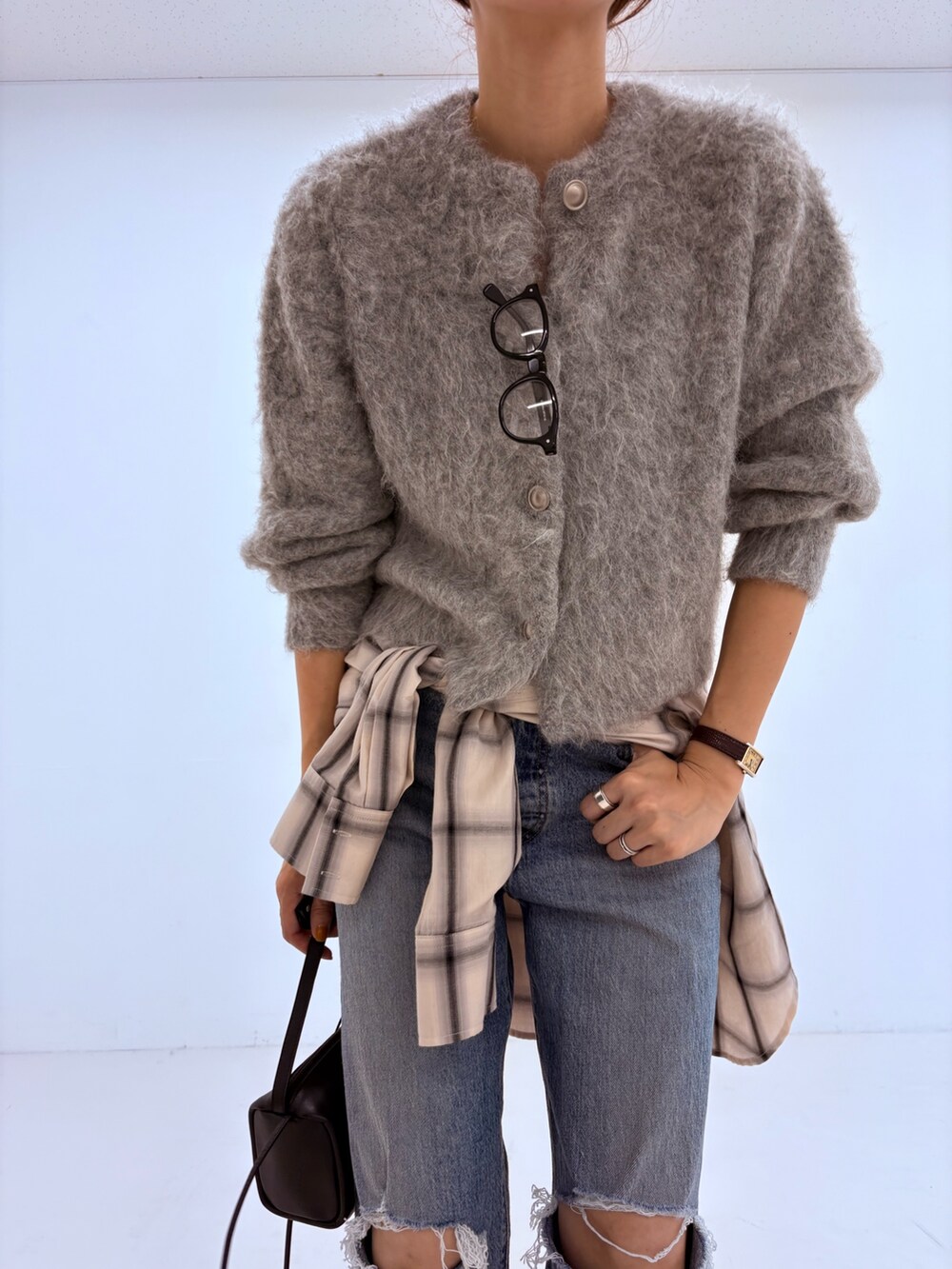 ブルー系のデニムパンツ、グリーン系のカーディガン/ボレロ、ホワイト系のピーコートを着用したレディースの秋コーディネートの6枚目の写真