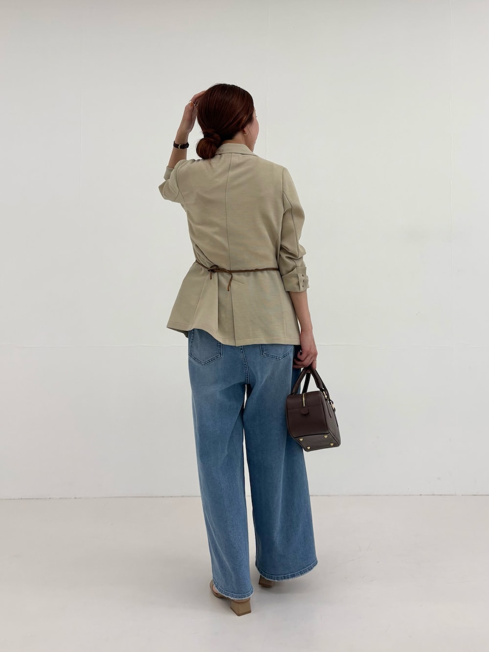 ベージュ系のその他アウター、イエロー系のTシャツ/カットソー、ブルー系のデニムパンツを着用したレディースの春コーディネートの3枚目の写真