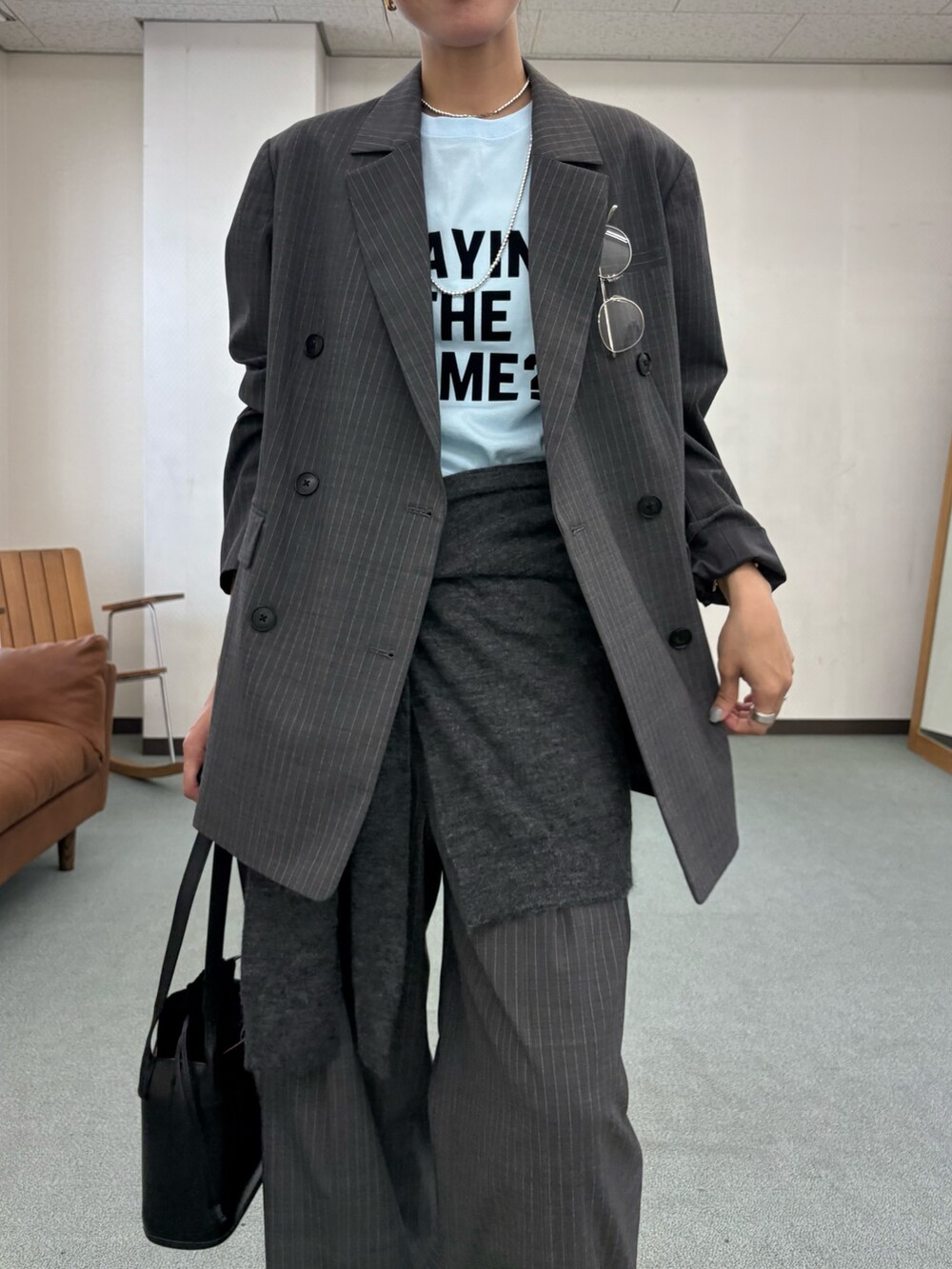 グレー系のその他パンツ、ホワイト系のスニーカー、ブラック系のハンドバッグを着用したレディースの秋コーディネートの6枚目の写真