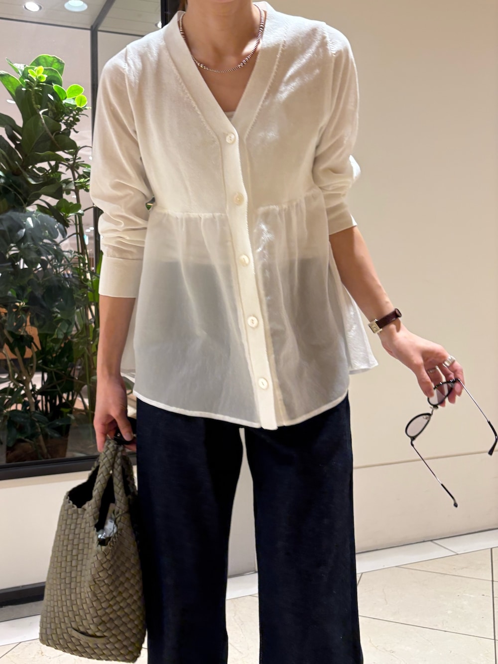 ホワイト系のカーディガン/ボレロ、ブルー系のデニムパンツ、グリーン系のトートバッグを着用したレディースの春コーディネートの5枚目の写真