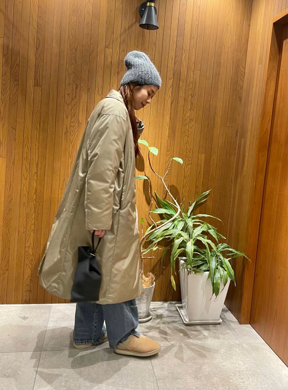 ブルー系のデニムパンツ、グレー系のカーディガン/ボレロ、ベージュ系のダウンジャケット/コートを着用したレディースの秋コーディネートの3枚目の写真