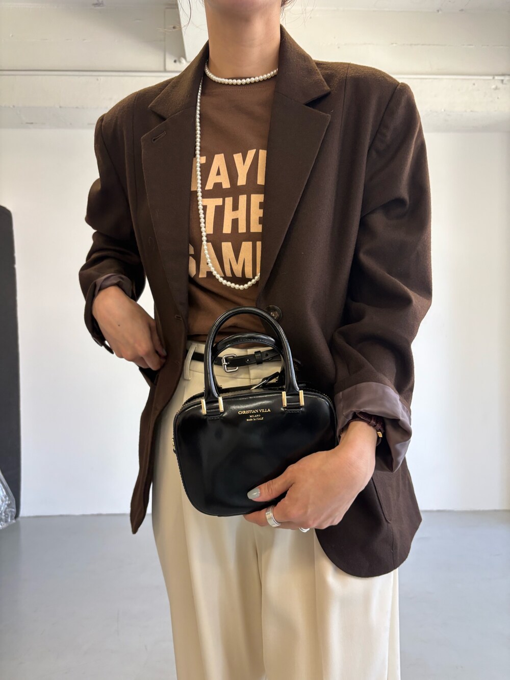 ブラウン系のその他アウター、ブラウン系のTシャツ/カットソー、ブラック系のショルダーバッグを着用したレディースの秋コーディネートの7枚目の写真