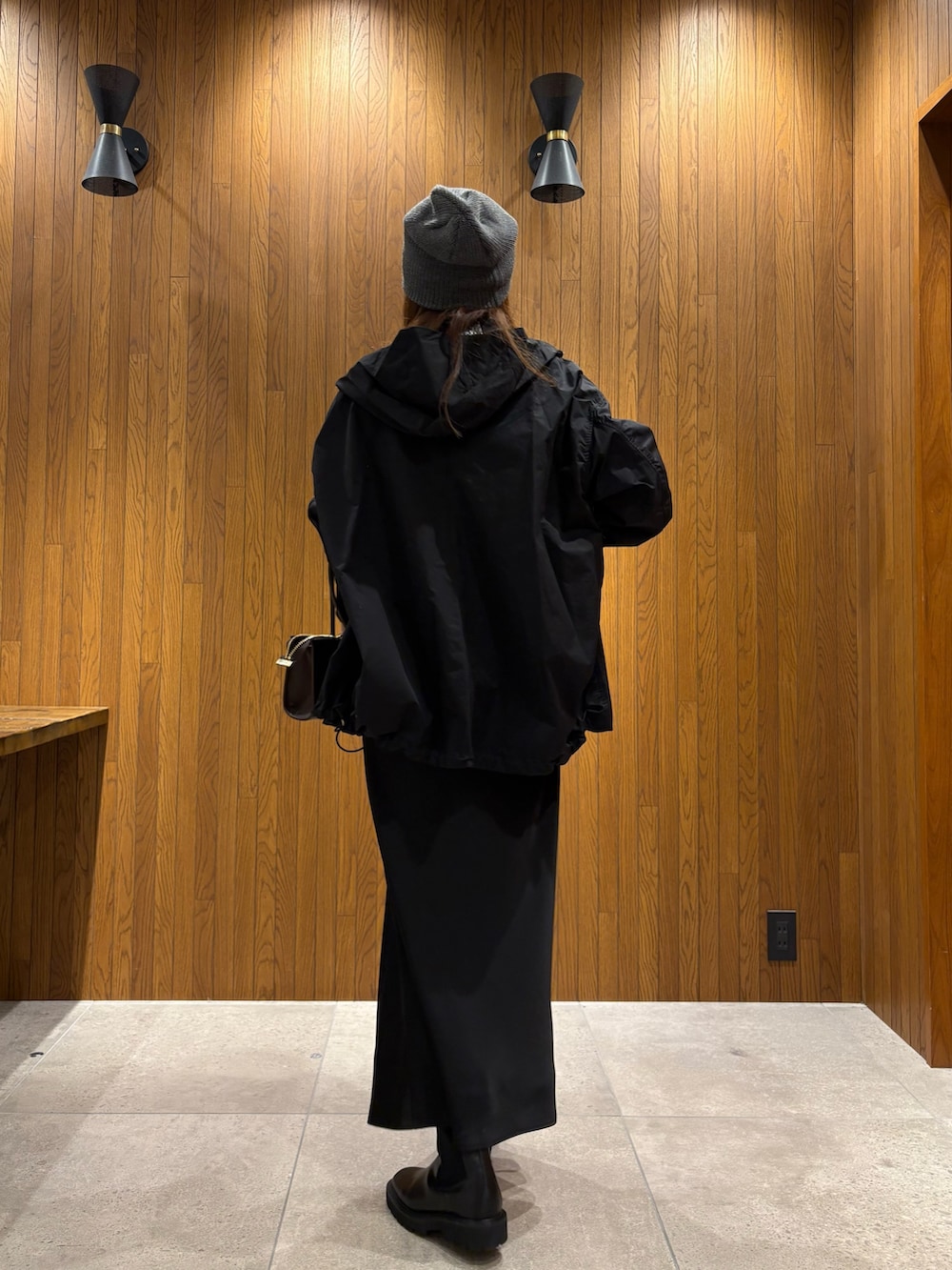 ブラック系のマウンテンパーカー、ブルー系のシャツ/ブラウス、ブラウン系のショルダーバッグを着用したレディースの冬コーディネートの3枚目の写真