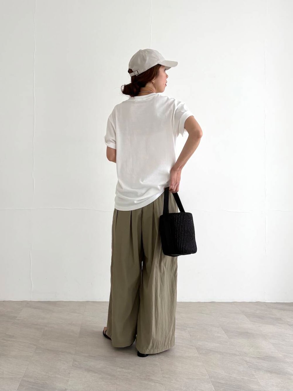 ベージュ系のその他パンツ、ブラック系のかごバッグ、ブラック系のサンダルを着用したレディースの夏コーディネートの4枚目の写真