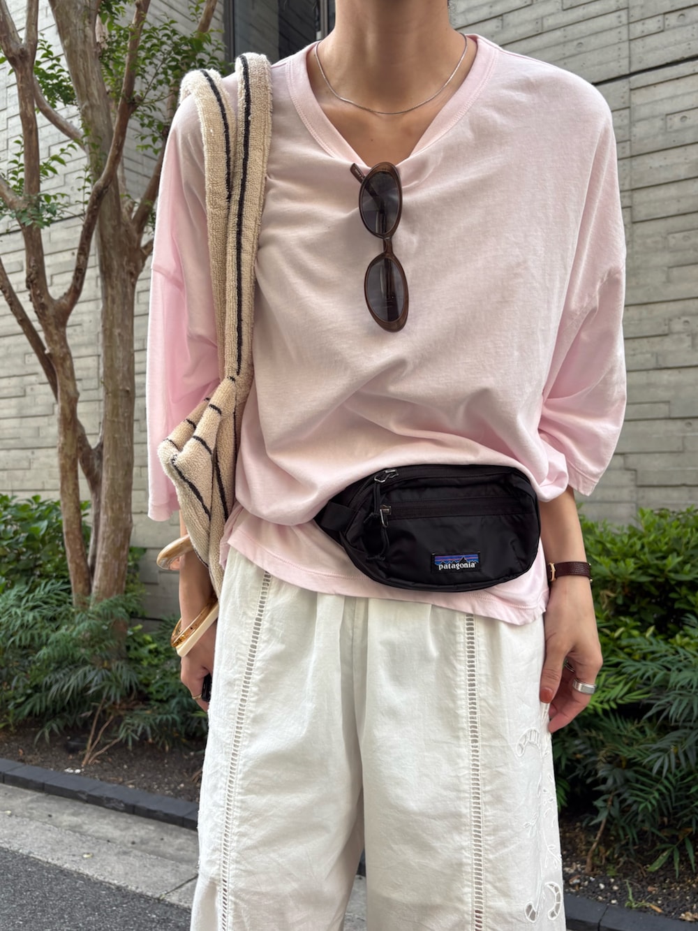 ピンク系のTシャツ/カットソー、グリーン系のスニーカー、ブラック系のボディバッグ/ウエストポーチを着用したレディースの春コーディネートの7枚目の写真