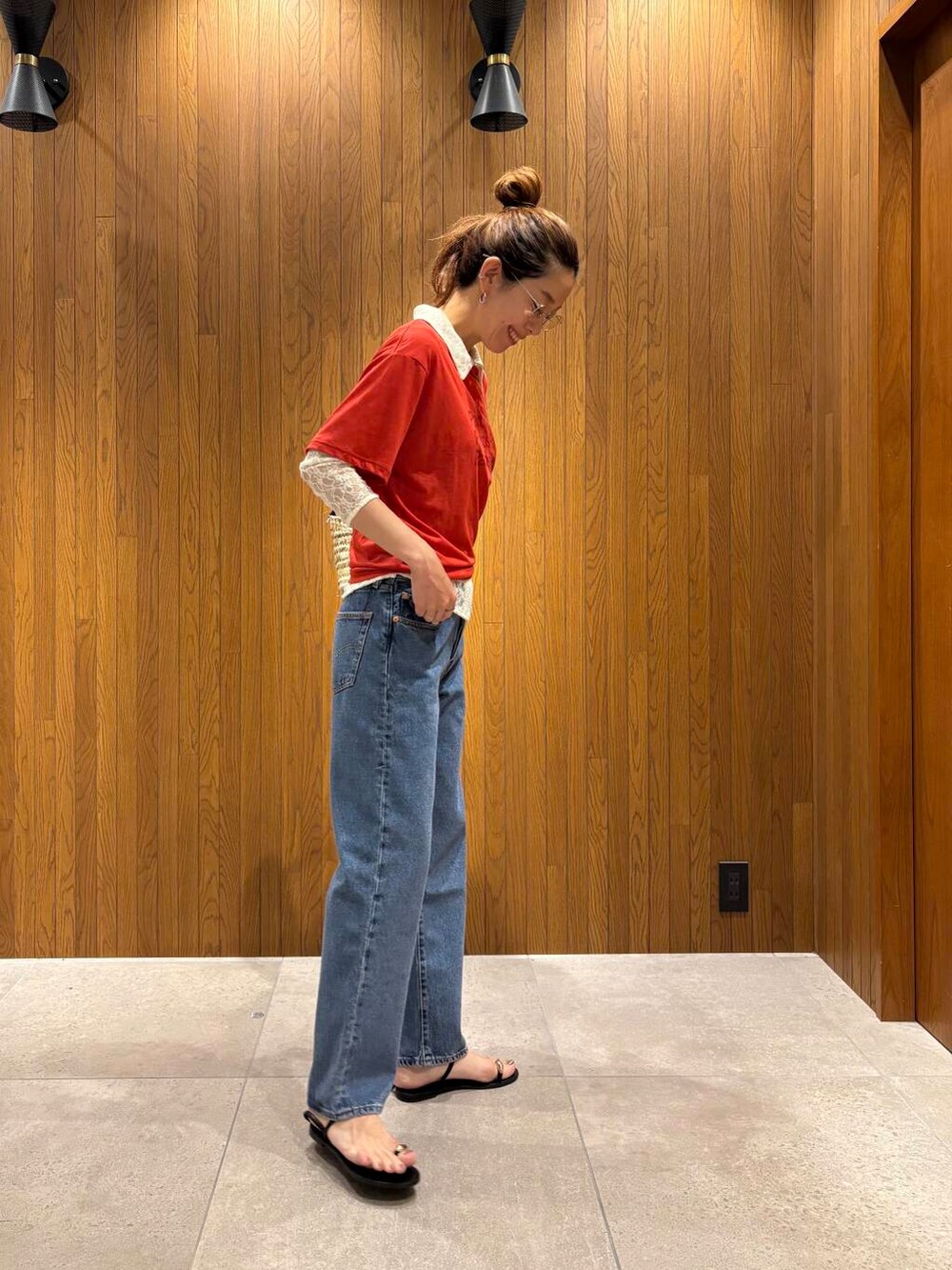 ブルー系のデニムパンツ、ブラック系のサンダル、レッド系のTシャツ/カットソーを着用したレディースの夏コーディネートの3枚目の写真
