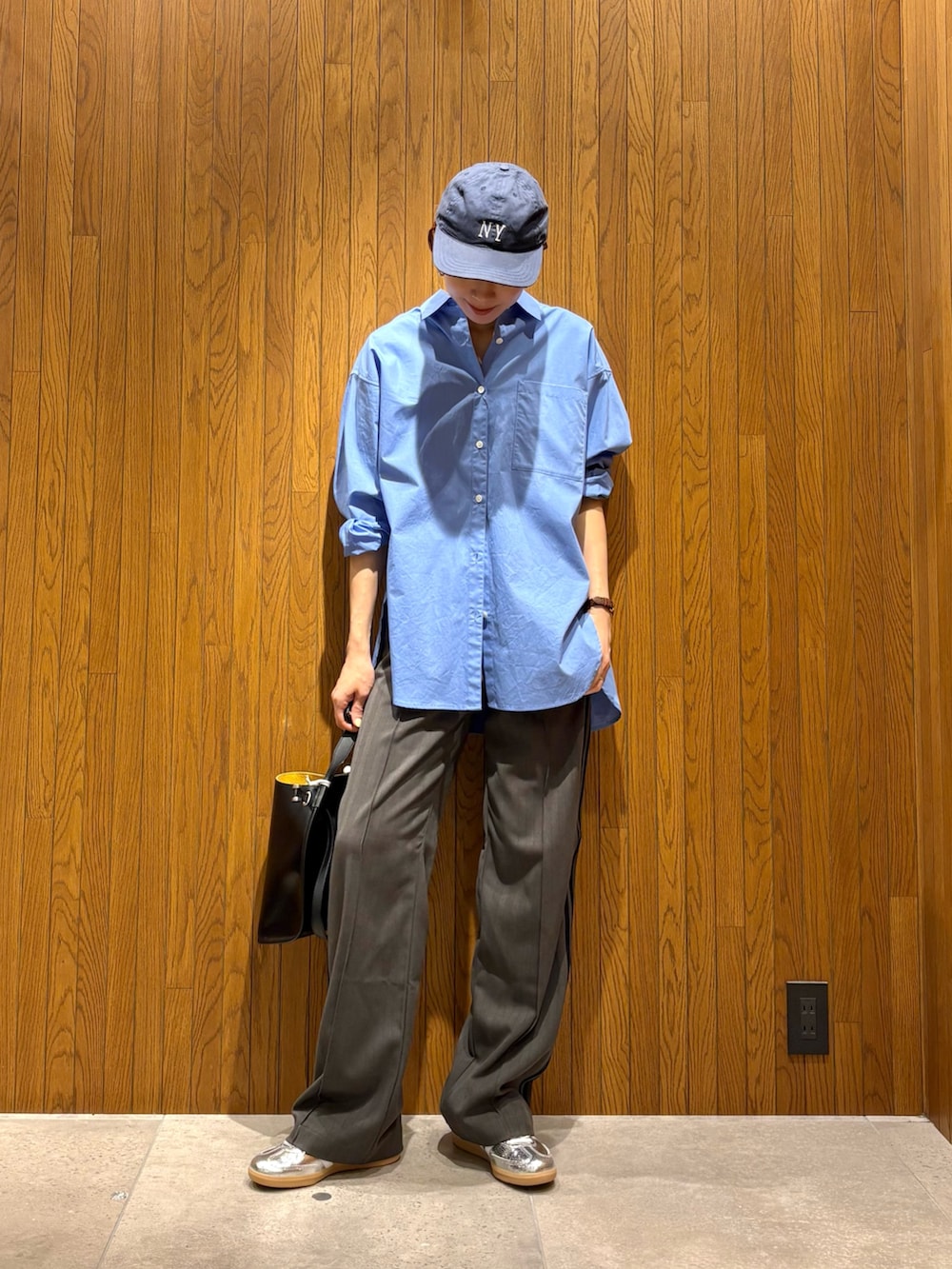 ブルー系のシャツ/ブラウス、ブラック系のハンドバッグ、シルバー系のスニーカーを着用したレディースの春コーディネートの4枚目の写真