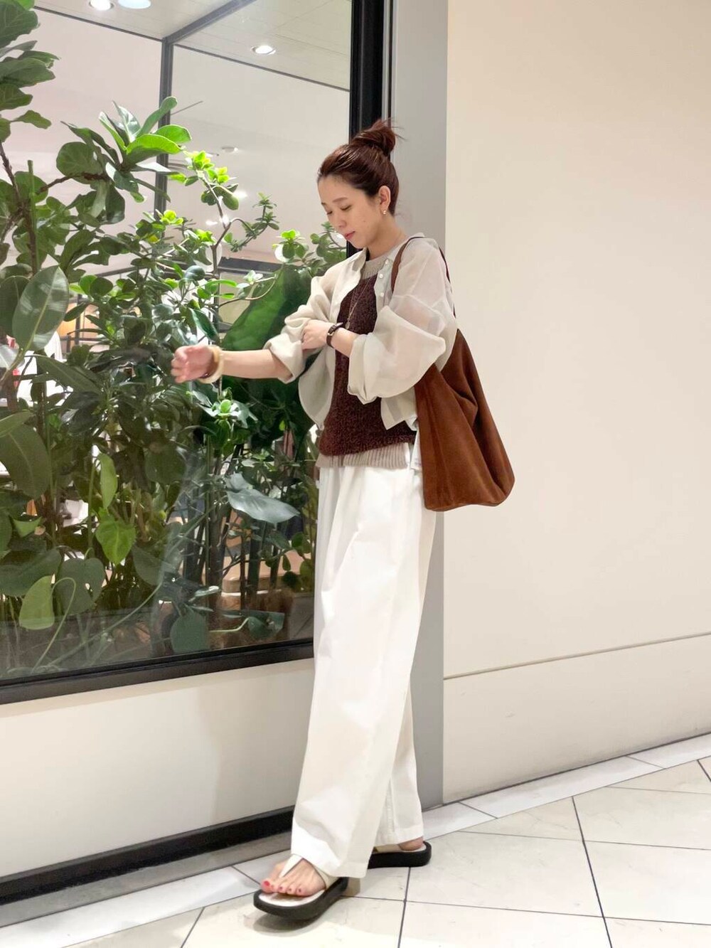 イエロー系のニット/セーター、ホワイト系のその他パンツ、ブラウン系のキャミソールを着用したレディースの春コーディネートの6枚目の写真