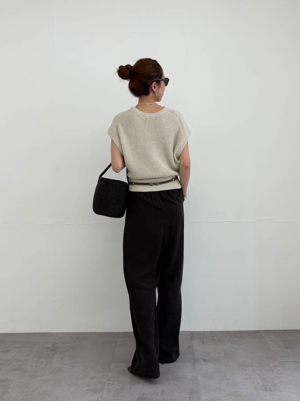 ブラック系のかごバッグ、ブラック系のサンダル、ベージュ系のベストを着用したレディースの夏コーディネートの3枚目の写真