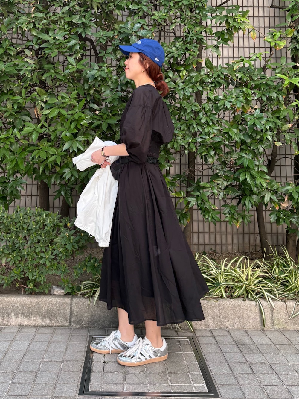 ホワイト系のブルゾン、ブラック系のワンピース、ブラック系のボディバッグ/ウエストポーチを着用したレディースの春コーディネートの6枚目の写真