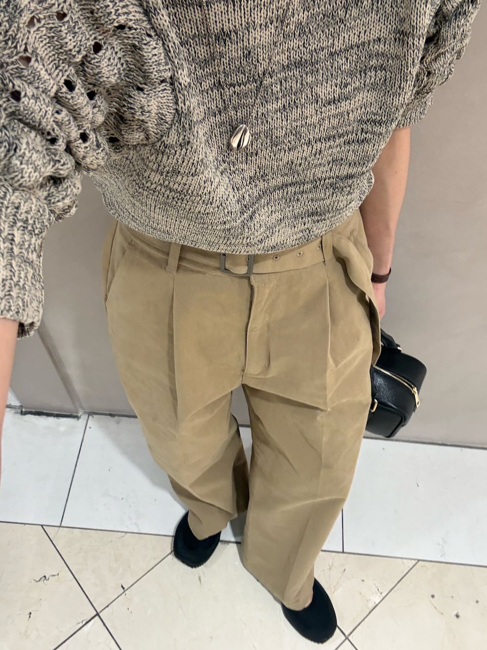 ベージュ系のその他パンツ、ブラック系のハンドバッグ、ホワイト系のニット/セーターを着用したレディースの春コーディネートの6枚目の写真