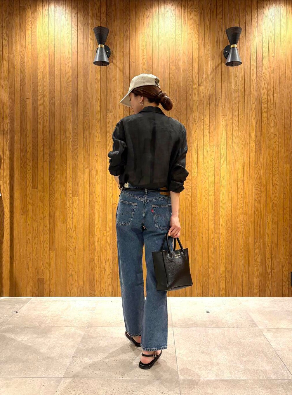 ブラック系のその他アウター、ブルー系のデニムパンツ、ベージュ系のキャップを着用したレディースの春コーディネートの3枚目の写真