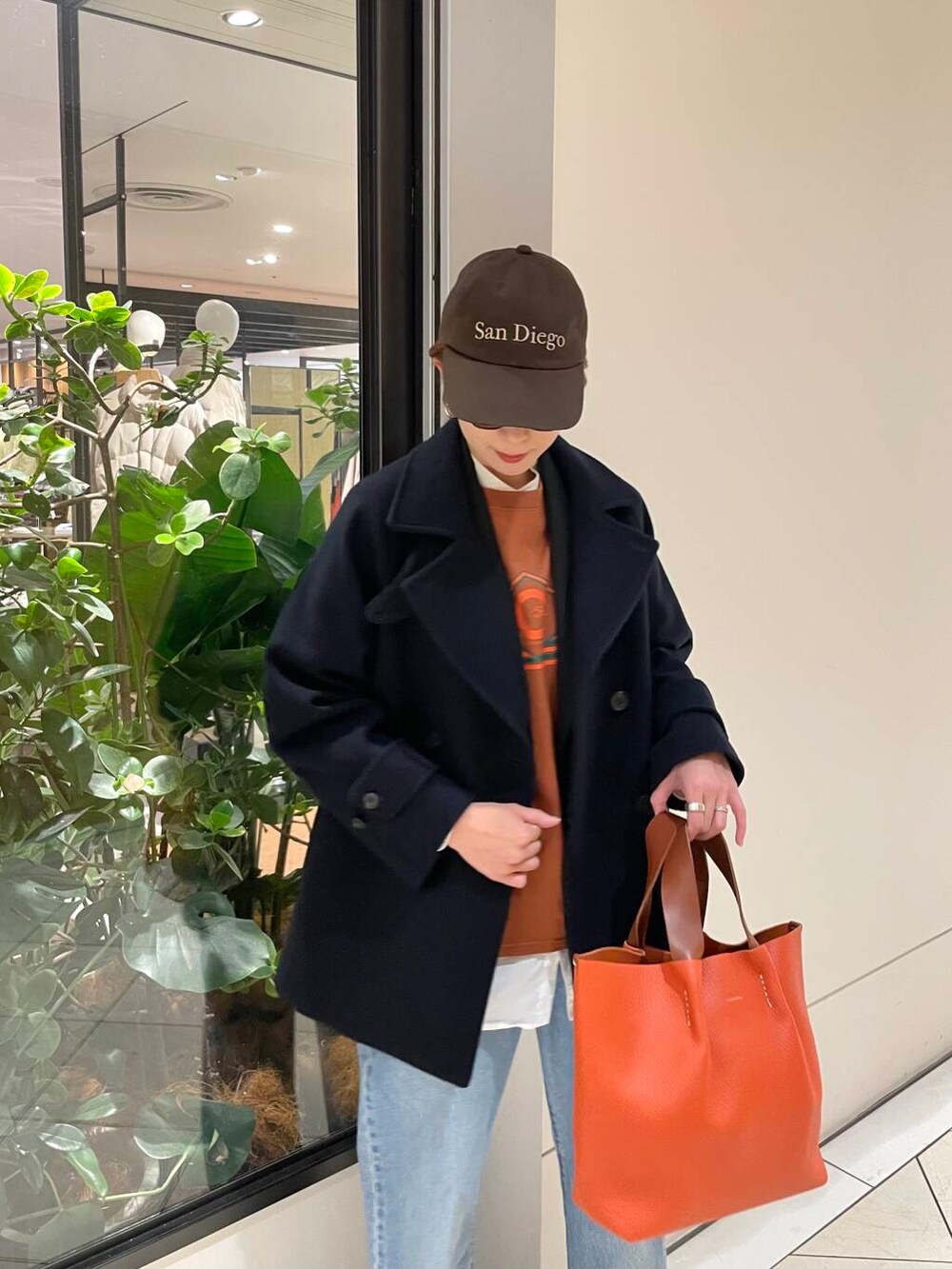 ブルー系のピーコート、ブルー系のデニムパンツ、ブラック系のブーツを着用したレディースの冬コーディネートの6枚目の写真