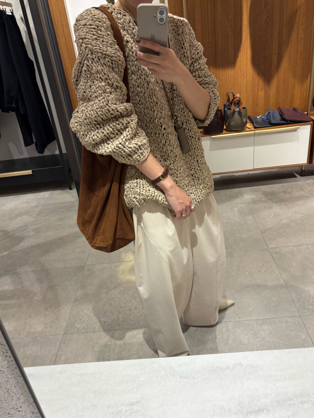 グレー系のニット/セーター、ホワイト系のその他パンツ、ブラウン系のトートバッグを着用したレディースの秋コーディネートの8枚目の写真