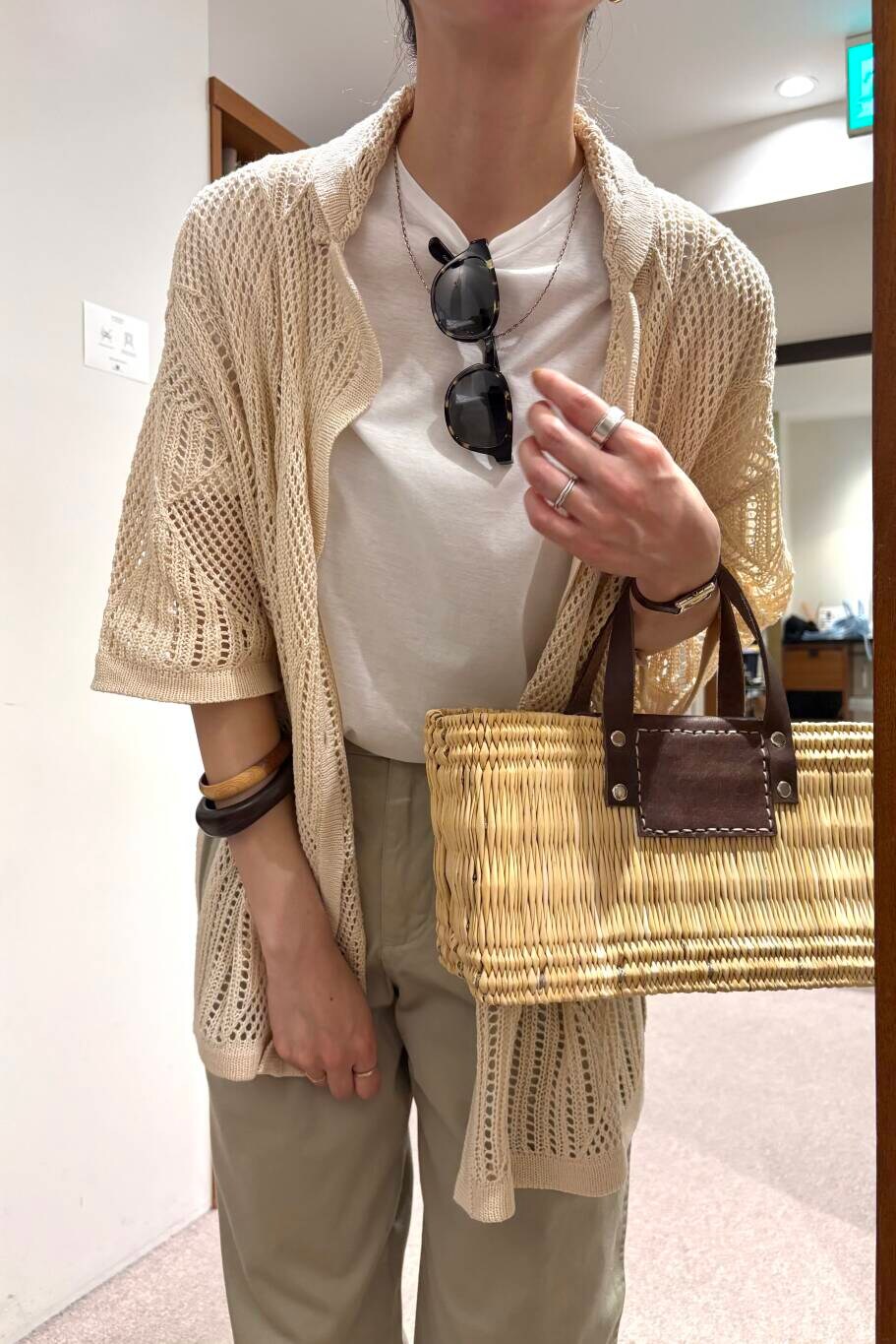 ブラウン系のかごバッグ、ホワイト系のその他アウター、ゴールド系のサンダルを着用したレディースの春コーディネートの6枚目の写真