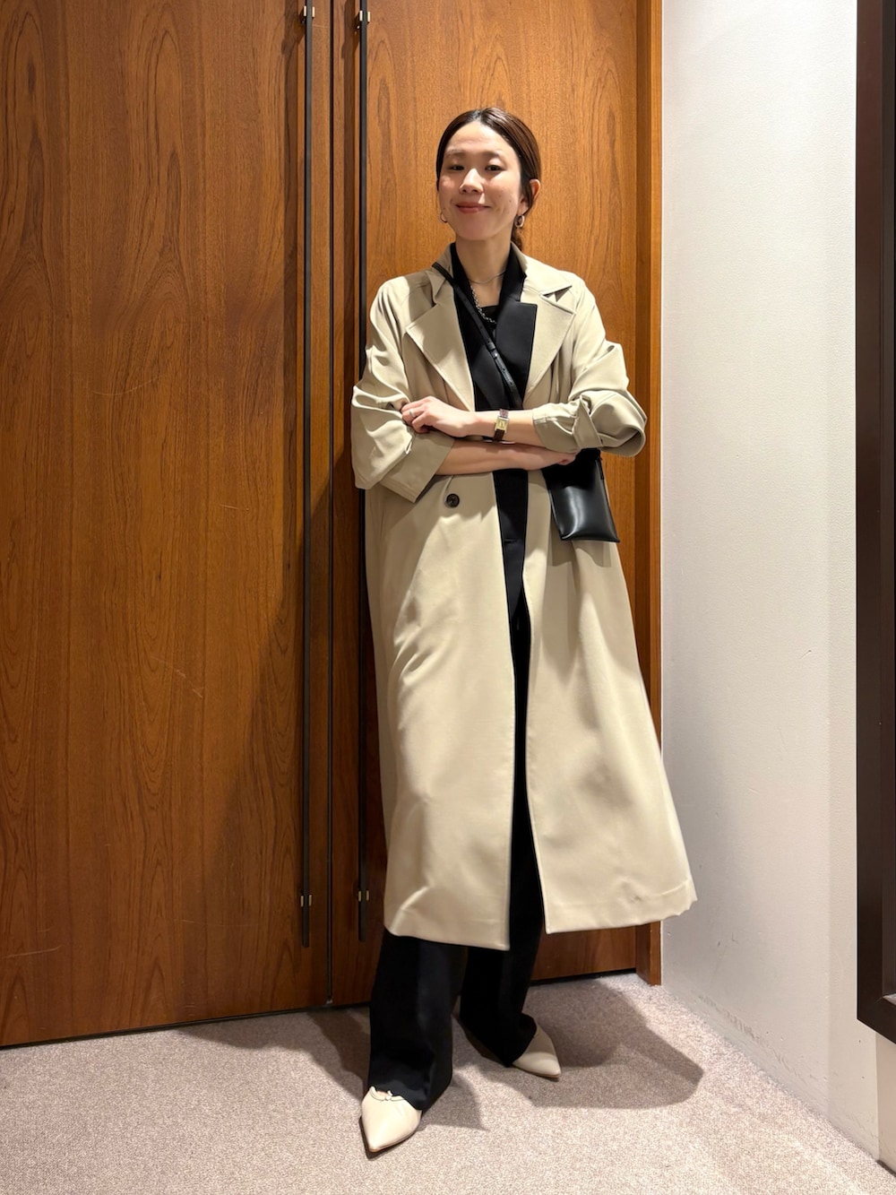 ベージュ系のトレンチコート、ブラック系のその他パンツ、ブラック系のその他アウターを着用したレディースの冬コーディネートの6枚目の写真
