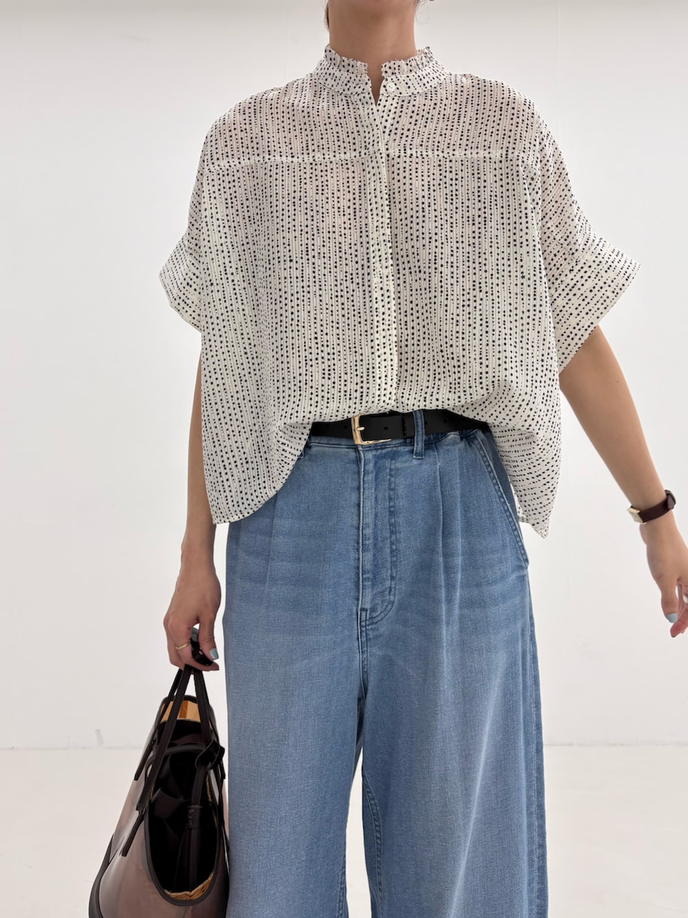 ホワイト系のシャツ/ブラウス、ブラウン系のかごバッグ、ブルー系のデニムパンツを着用したレディースの春コーディネートの5枚目の写真