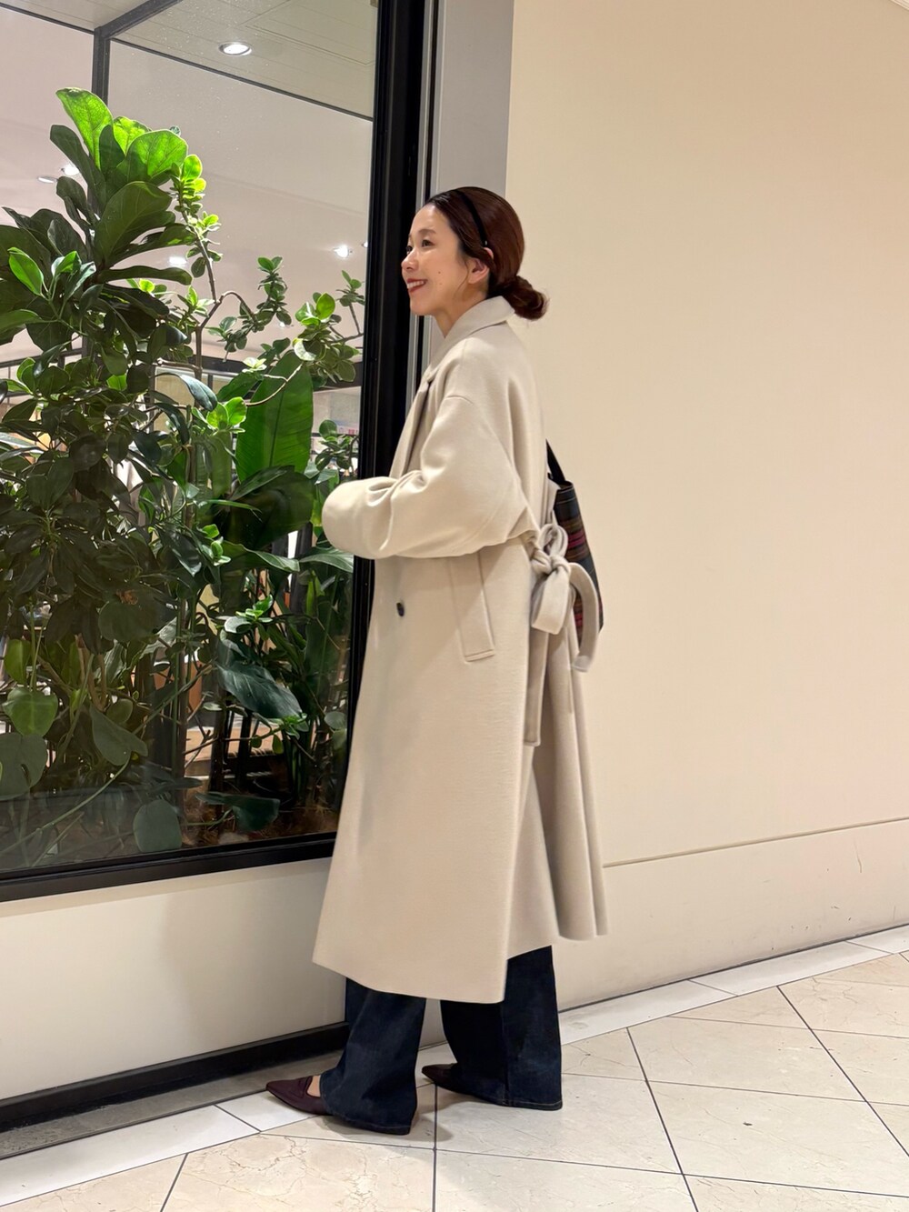 ブラウン系のニット/セーター、ブルー系のデニムパンツ、レッド系のパンプスを着用したレディースの秋コーディネートの5枚目の写真