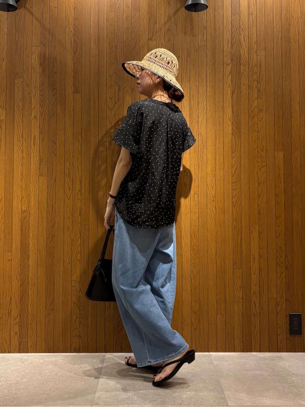 ブラック系のシャツ/ブラウス、ブルー系のデニムパンツ、ブラック系のサンダルを着用したレディースの春コーディネートの4枚目の写真
